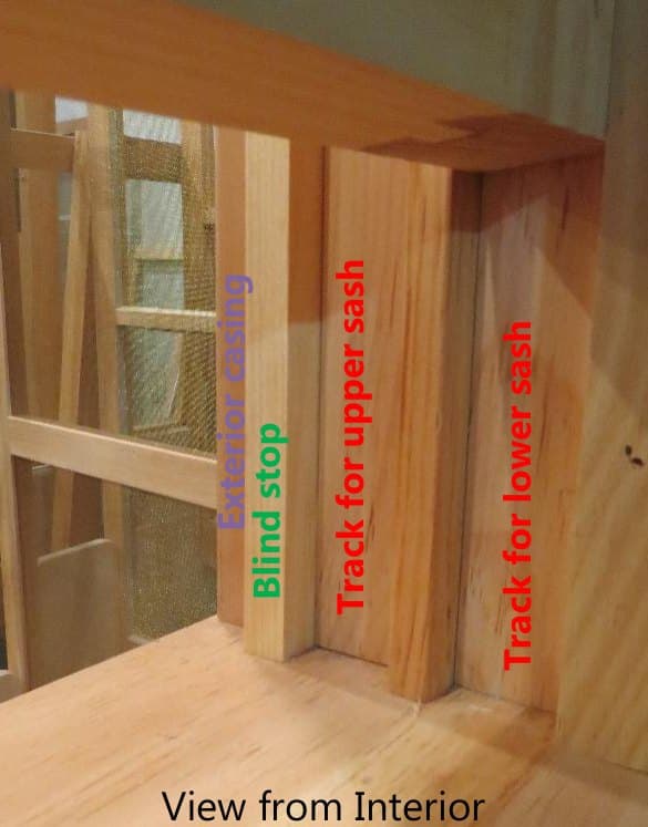 Close-up of a window jamb from the interior showing the blind stop and the tracks for the upper and lower sash