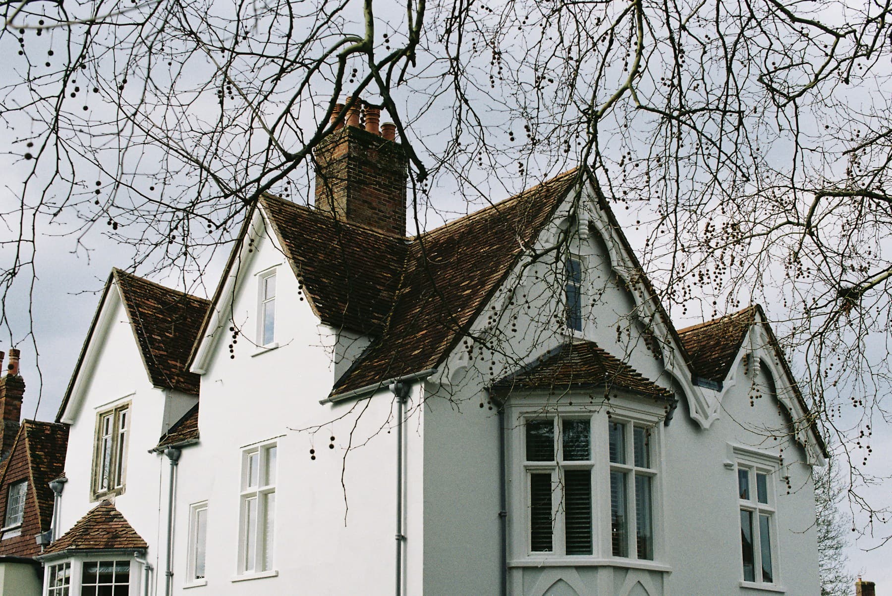 Traditional white home with bay windows and gabled roofs