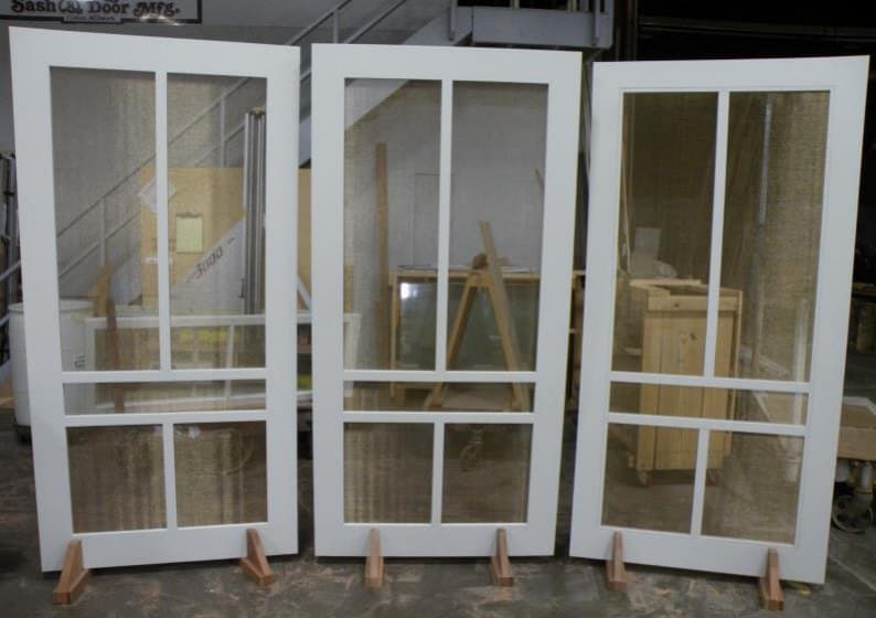 Three painted wood screen doors with divided upper lites
