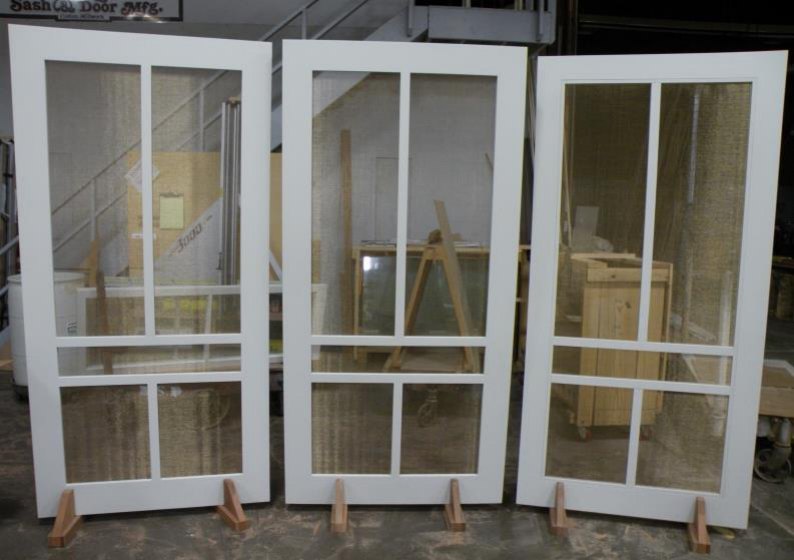 Three painted wood screen doors with divided upper lites