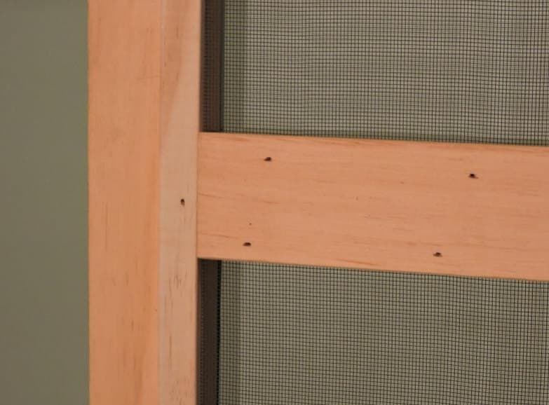 Mortise-and-tenon joinery at the center bar of a wood combination storm window