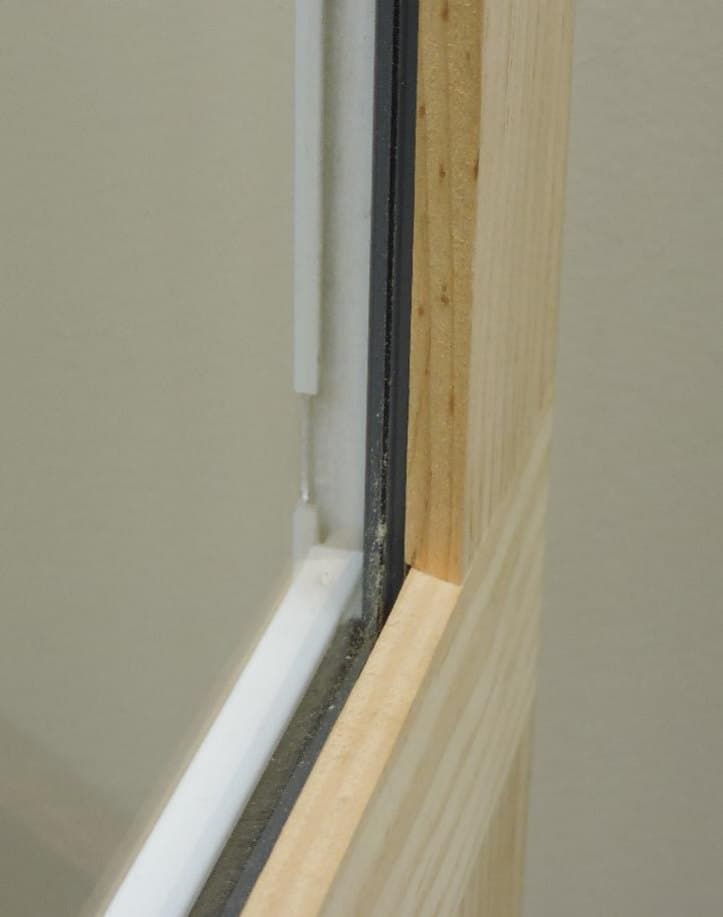 Self-storing wood storm window center bar and weatherstrip from the exterior