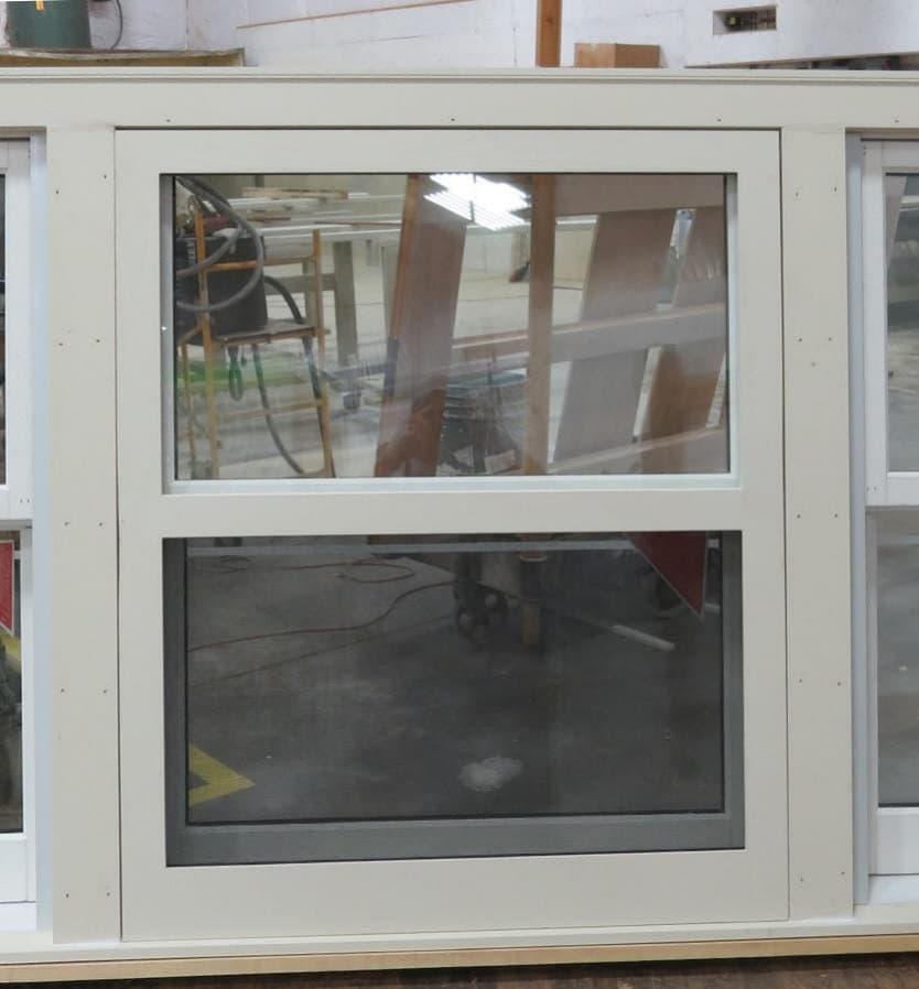 Self-storing wood storm window installed in the brickmould