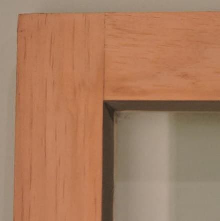 Upper corner joint of a traditional wood storm window viewed from the exterior