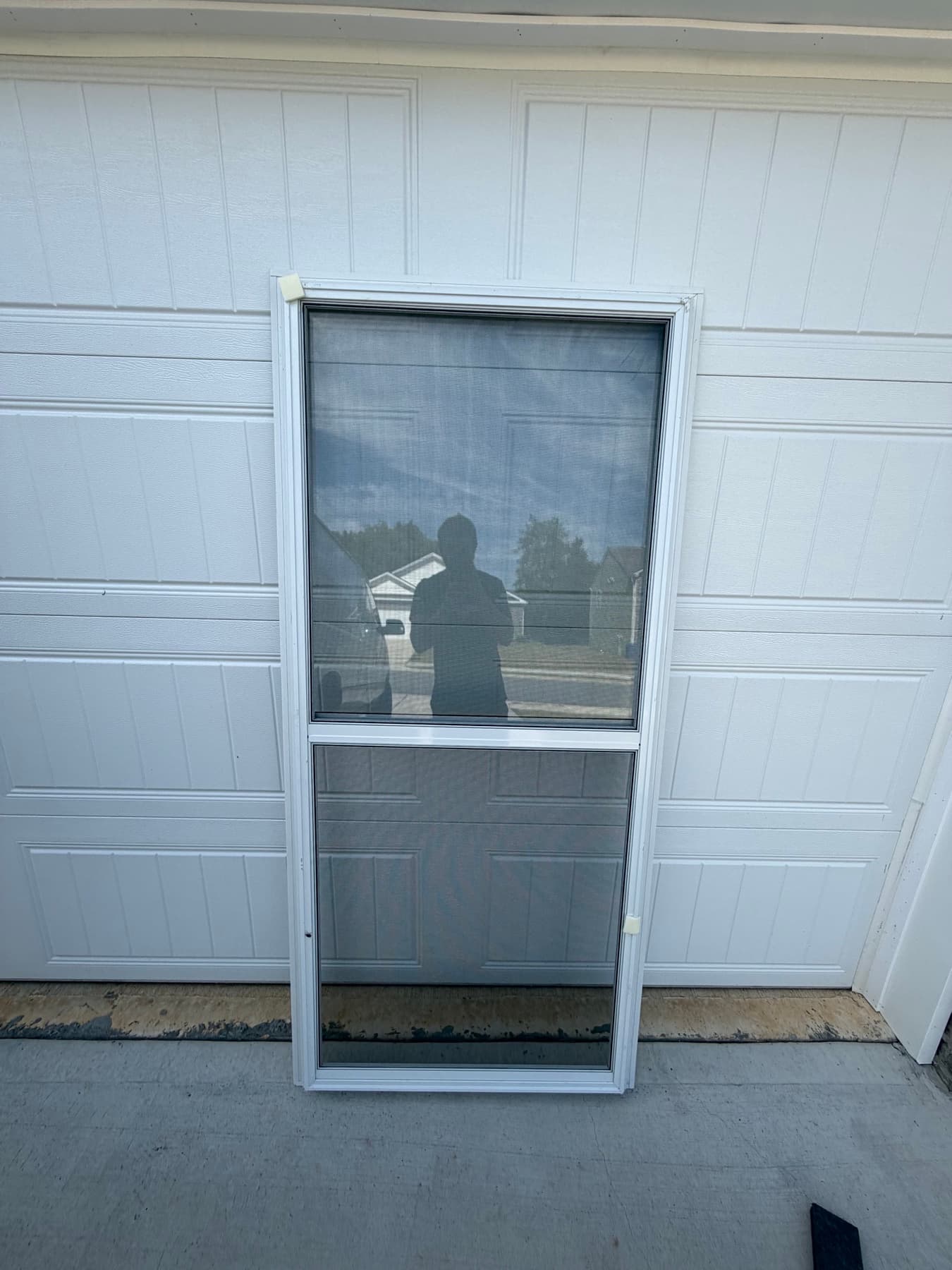 Delivered storm door standing in front of a garage
