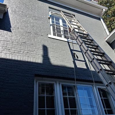 Upper-story storm window installation on a painted brick home