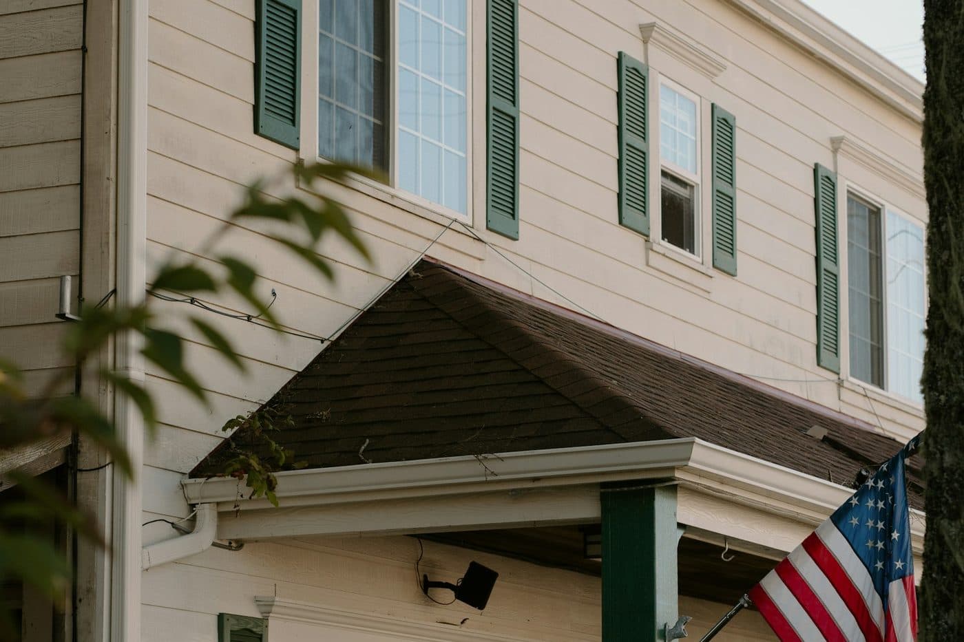 A white house with shutters and a covered porch