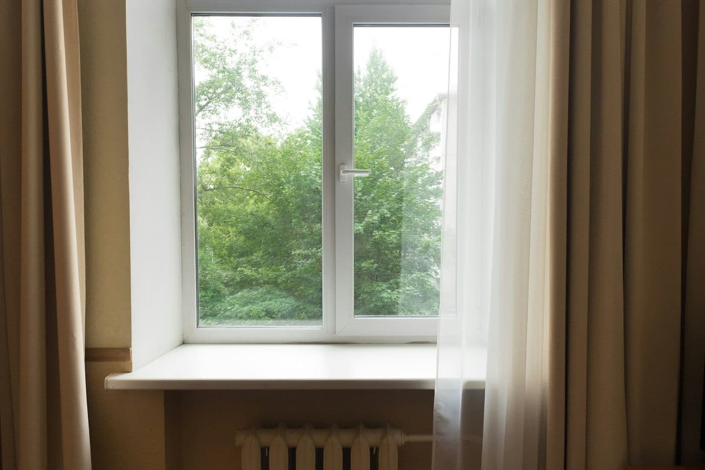 A quiet bedroom window with soft curtains