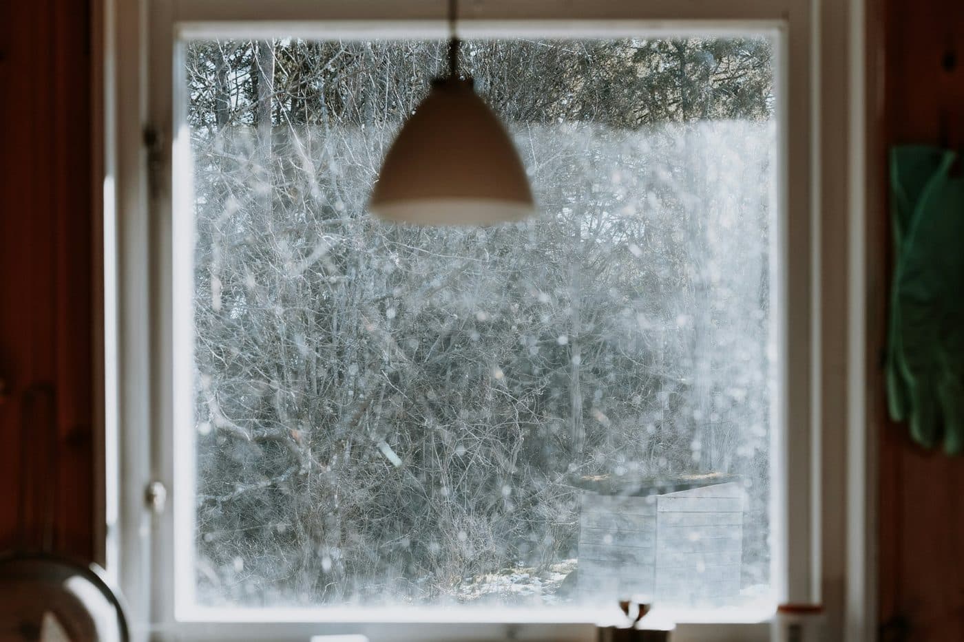 A frosted window with a pendant light inside a warm room