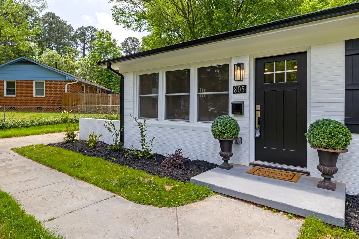 A house entry with a front door, white trim, a landing and nearby walls